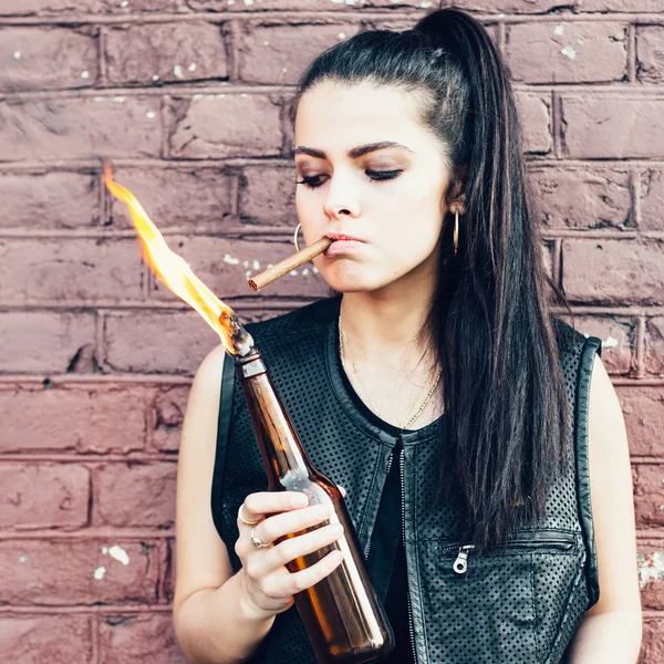 Bad girl lighting up a cigarette from Molotov cocktail bomb in her hand — Stock Photo, Image