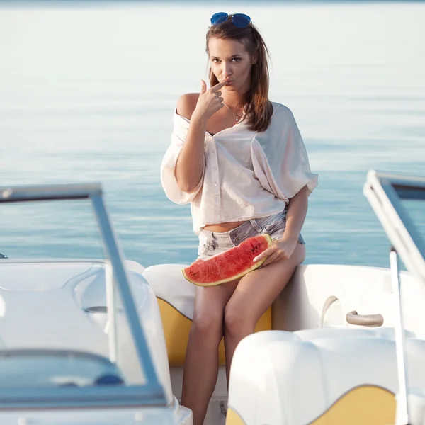 Bella ragazza con anguria posa su uno yacht — Foto Stock