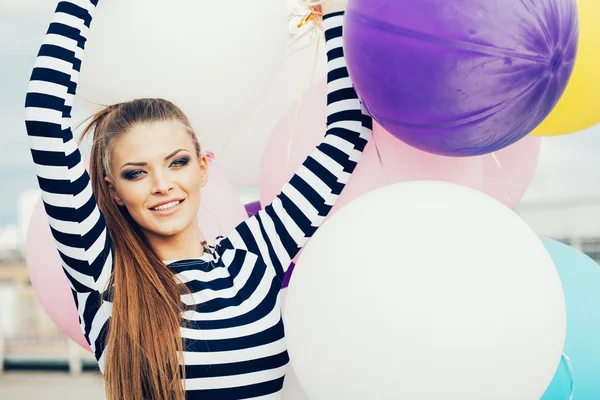 Joyeux jeune femme avec des ballons en latex coloré — Photo