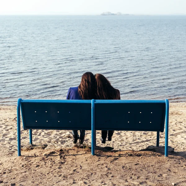 Twee slanke meisje ontspannen op de oever van de zee op avond — Stockfoto