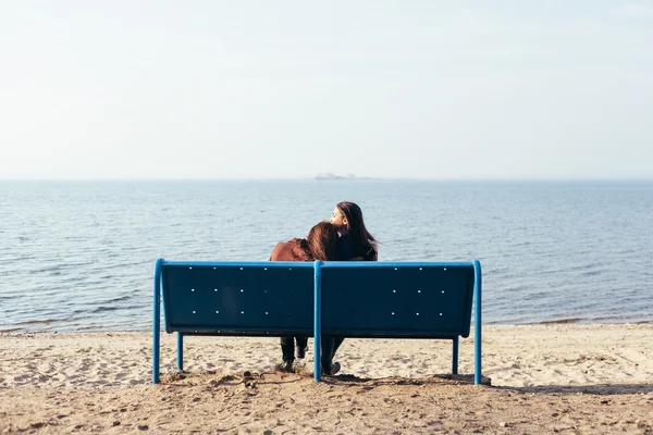 Two girl relaxing on shore of sea on evening — Stock Photo, Image