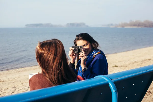 İki kız sahilde eski bir kamerayla resim çekme — Stok fotoğraf