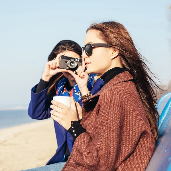 Hezká dívka fotografování její přítelkyně s šálkem kávy — Stock fotografie