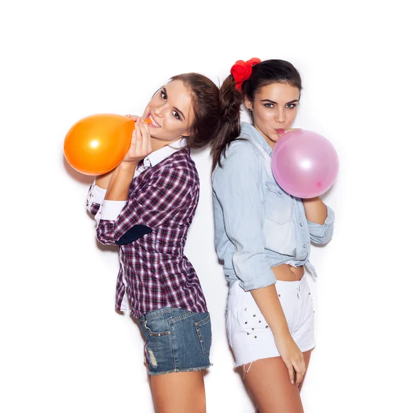 Two girlfriends inflate colored balloons — Stock Photo, Image