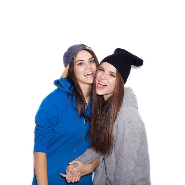 Two young stylish girlfriends in hoodies having fun together — Stock Photo, Image