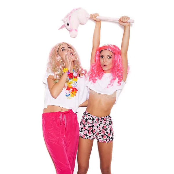 Sexy namoradas em perucas coloridas e roupas se divertir com unicórnio — Fotografia de Stock