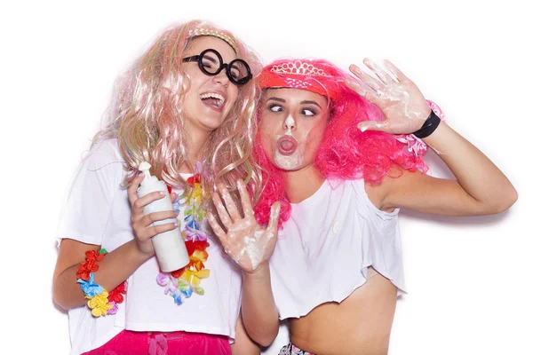 Funny girls in colored wigs and glasses stained with cream — Stock Photo, Image