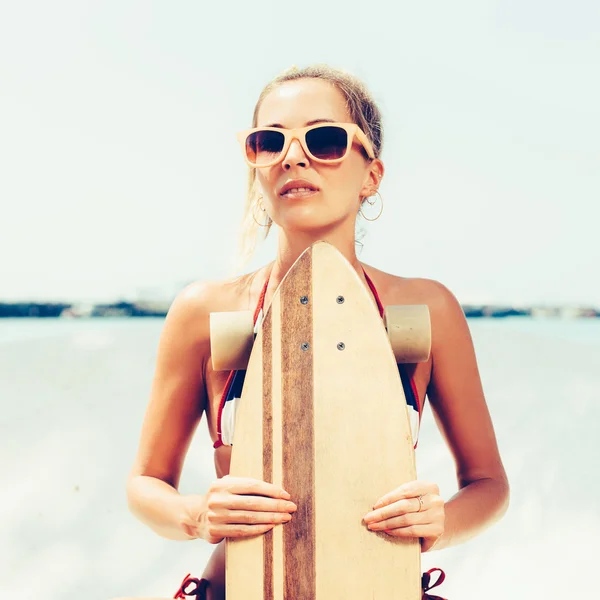 Сексуальная женщина в солнечных очках с длинной доской — стоковое фото