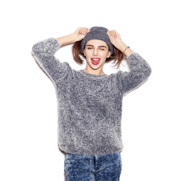Funky lány kötött pulóver és a kalap kacsintás és bemutatás nyelv — Stock Fotó