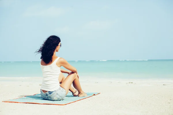 Giovane donna di moda seduta sulla spiaggia — Foto Stock