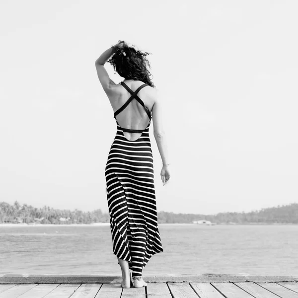 Junge hübsche Frau steht allein auf der Seebrücke — Stockfoto