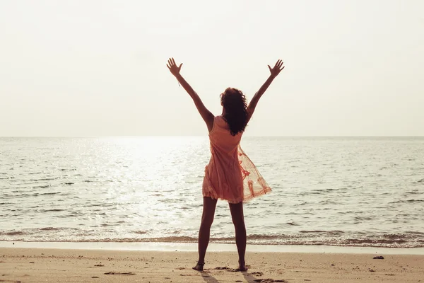 Femme jouissant de la liberté se sentant heureux à la plage au coucher du soleil — Photo