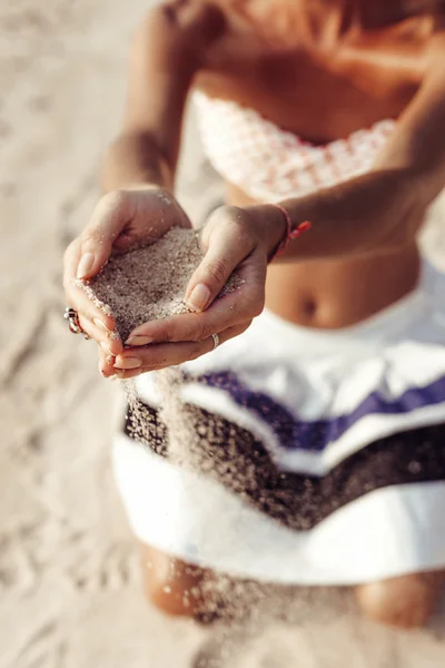 女人手里拿着在沙滩上的沙子 — 图库照片