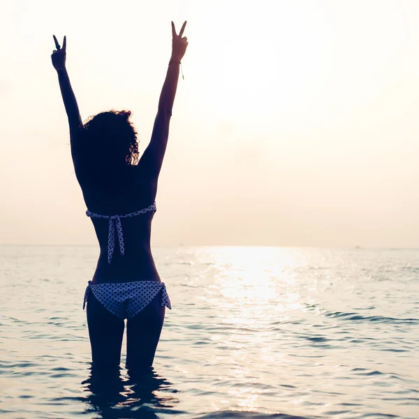 Žena se těší svobodě cítí šťastný na pláži při západu slunce — Stock fotografie