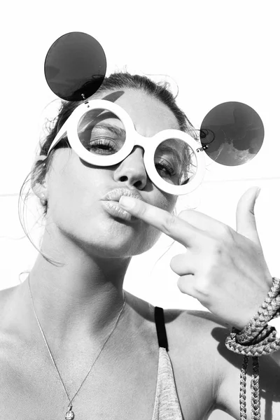 Young blonde woman in sunglasses kissing  middle finger — Stock Photo, Image