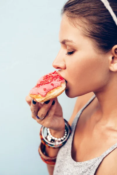 Attractive brunette sexy woman eating tasty donut — Stock Photo, Image