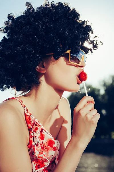 Szexi lány, haja fekete parókát cukorka, nyalóka — Stock Fotó