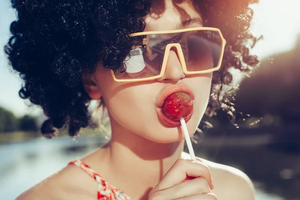 黒のかつらの髪とセクシーな女の子吸うロリポップ — ストック写真