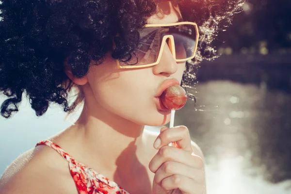 Sexy girl with black wig hair sucks lollipop — Stock Photo, Image