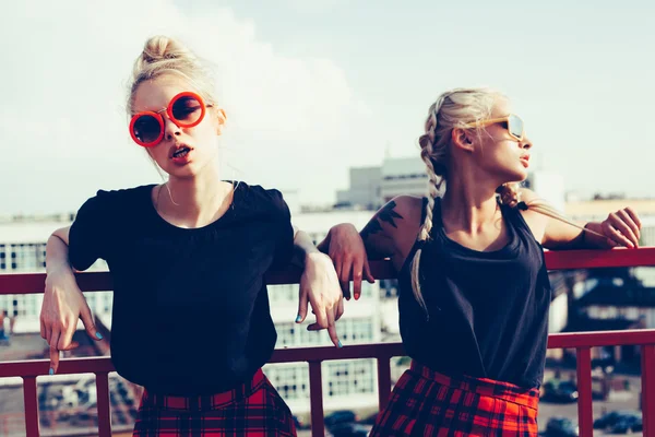 Due graziose sorelle hipster contro il muro bianco urbano — Foto Stock