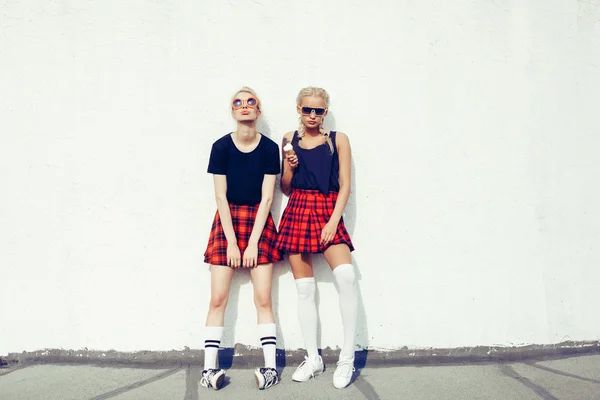Duas irmãs hipster bonitas contra a parede branca urbana — Fotografia de Stock