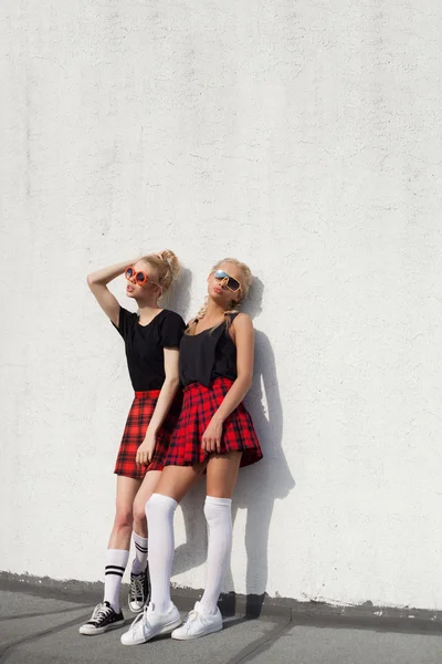 Dos hermanas hipster bonita contra la pared blanca urbana — Foto de Stock