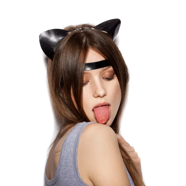 Женщина с кожаными кошачьими ушами облизывает плечо — стоковое фото