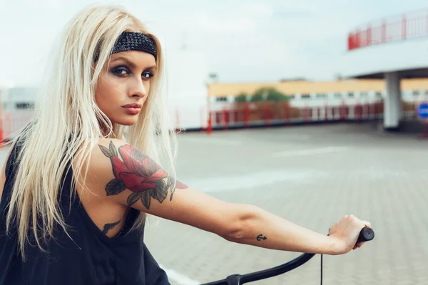 Mulher loira bonita com bicicleta na cidade — Fotografia de Stock