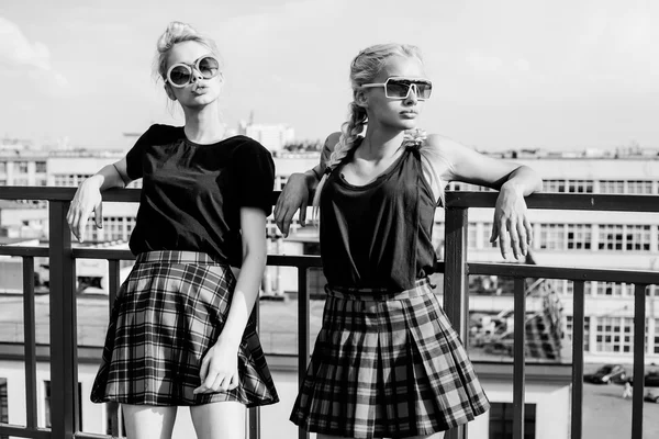 Zwei hübsche Hipster-Schwestern gegen urbane weiße Wand — Stockfoto