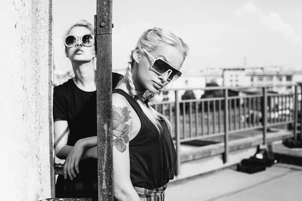 Two pretty hipster sisters against urban white wall — Stock Photo, Image