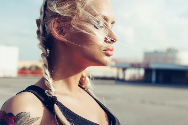 Jonge vrouw met gevlochten pigtails. Zachte zonnige kleuren. — Stockfoto