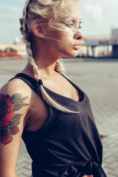 Jonge vrouw met gevlochten pigtails. Zachte zonnige kleuren. — Stockfoto