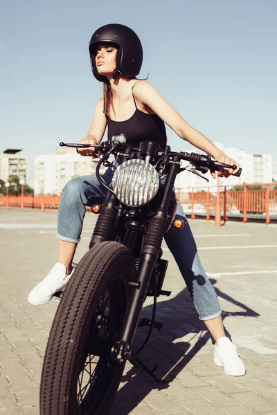 Menina motociclista na motocicleta olhando para o pôr do sol — Fotografia de Stock