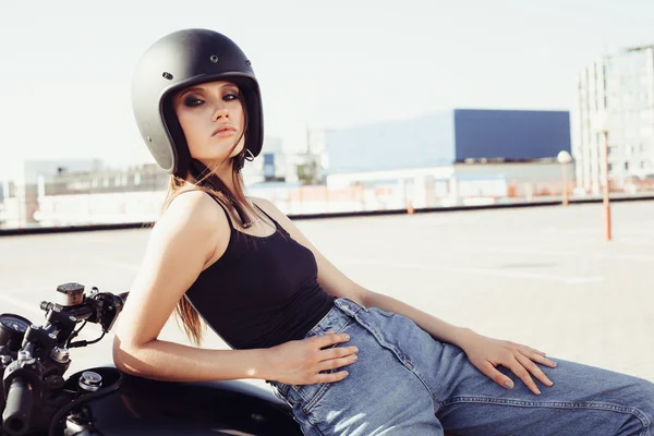 Biker meisje in zittend op aangepaste motorfiets helm — Stockfoto