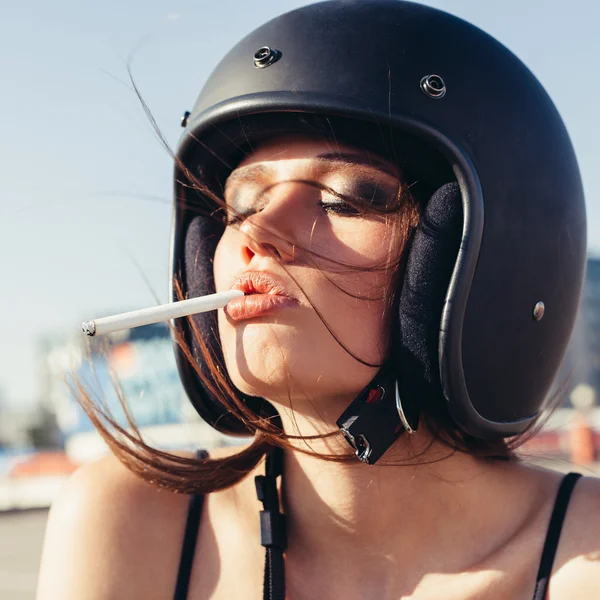 Vacker kvinna i Motorcykel hjälm rökning sigarette — Stockfoto