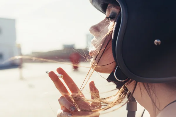 Belle femme en casque de moto fumer sigarette — Photo