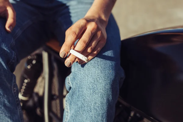 Mujer joven en motocicleta fumar sigarette — Foto de Stock