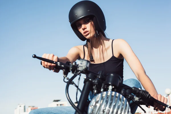 Байкерша сидит на винтажном мотоцикле — стоковое фото