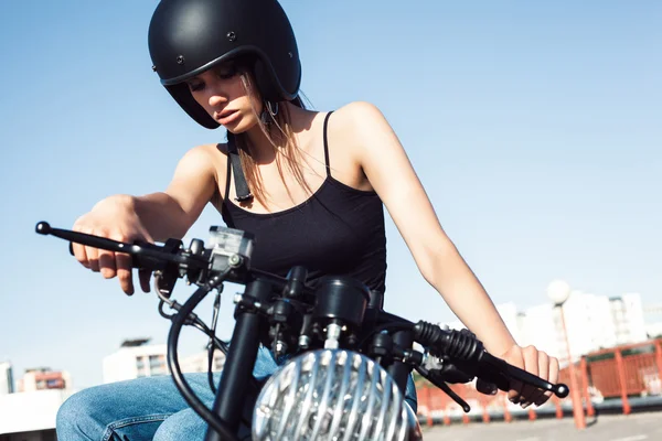 Байкерша сидит на винтажном мотоцикле — стоковое фото