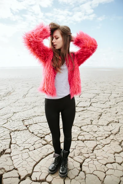 Joven modelo femenino caminando en tierra seca — Foto de Stock