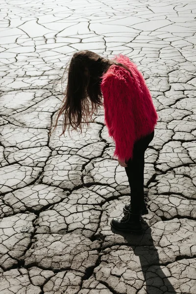 Joven modelo femenino caminando en tierra seca — Foto de Stock