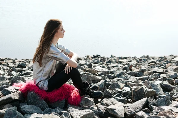 Mujer joven disfrutar en el sol en la playa de piedra por mar —  Fotos de Stock