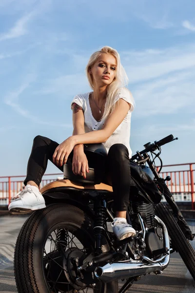 骑自行车的女孩坐在老式的定制摩托车 — 图库照片
