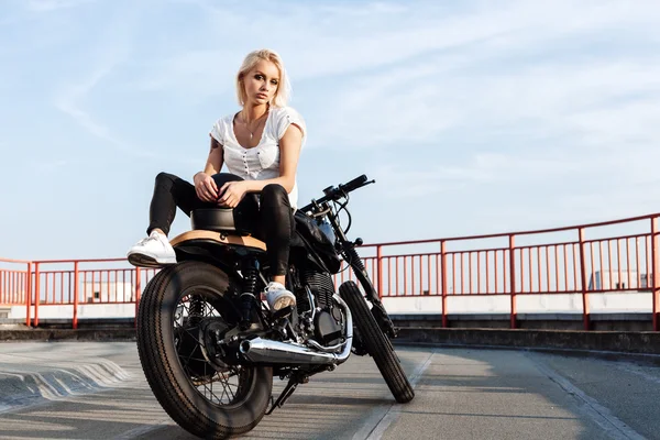 Chica motociclista sentada en motocicleta personalizada vintage — Foto de Stock