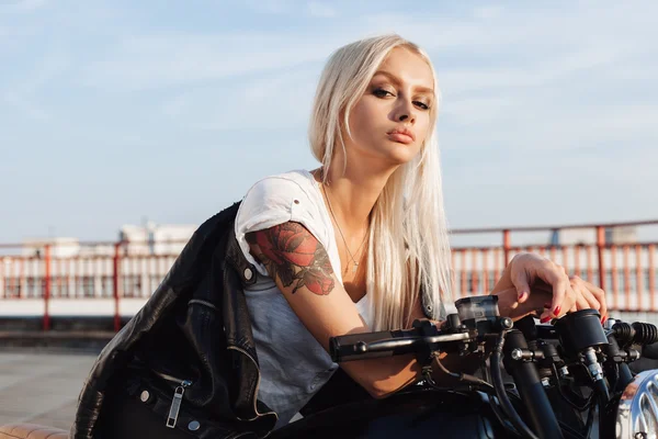 Biker woman sitting on vintage custom motorcycle — Stok fotoğraf