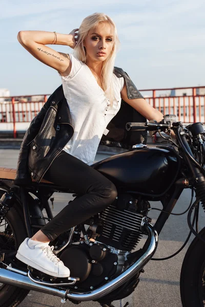 Chica motociclista sentada en motocicleta personalizada vintage — Foto de Stock