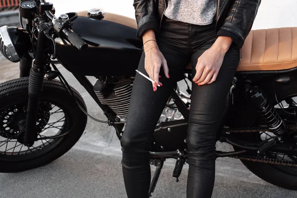 Jonge vrouw op motorfiets roken sigaretten — Stockfoto