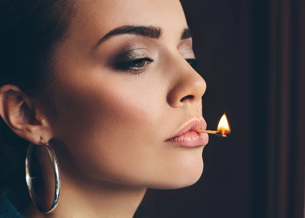 Γυναίκα με τέλειο δέρμα κρατώντας τα χείλη της με μια φλόγα του αγώνα — Φωτογραφία Αρχείου