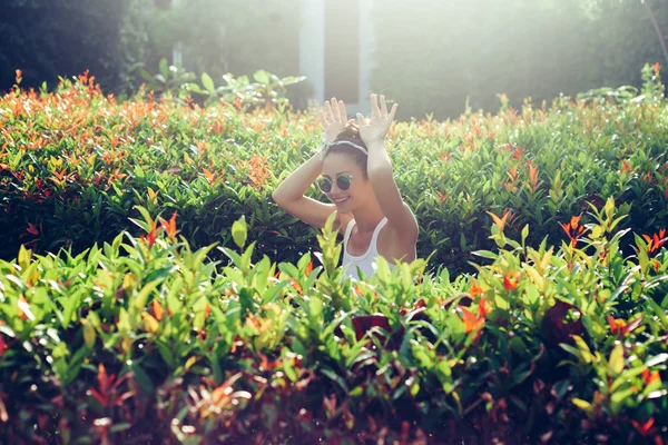 Sexy female model showing rabbit sitting in bushes — Stock fotografie