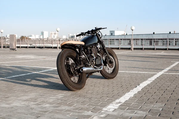 Vintage motorcycle in parking lot during sunset